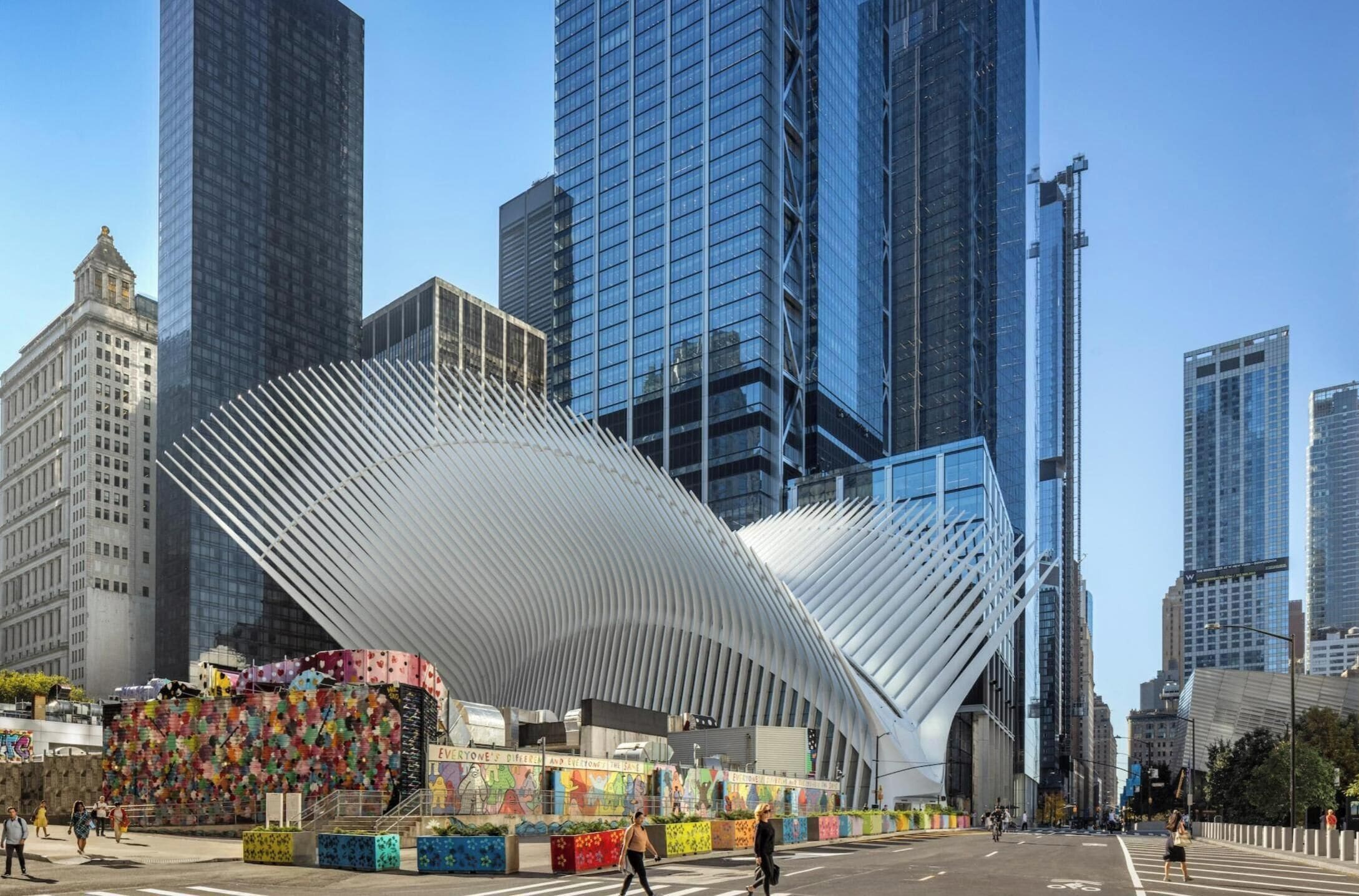 A modern urban street with a distinctive curved building and a colorful mural.