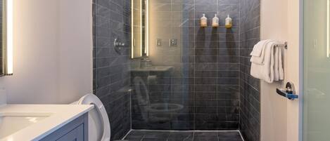 A modern bathroom with a toilet, sink, and shower area.