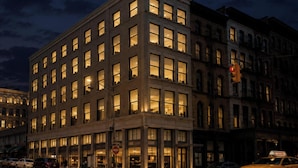 A multi-story building with illuminated windows, a visible street corner, and a traffic light. - Duane Street Hotel Tribeca, Belvilla District 6 Formerly Sonder (New York)