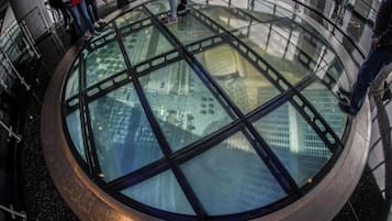 Un pavimento di vetro circolare con vista sugli edifici sottostanti.