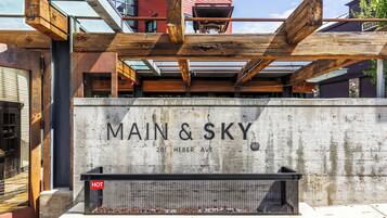 A building with the sign "MAIN & SKY" at 2011 HEBER AVE, featuring a concrete facade and wooden beams.