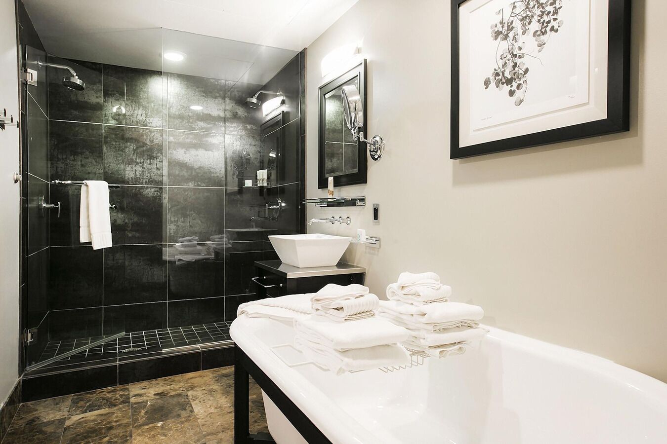 Un bagno moderno con doccia a vetro, lavandino bianco e vasca da bagno ampia.