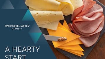 A cheese and ham platter on a slate board with the text "SPRINGHILL SUITES MARRIOTT A HEARTY START".