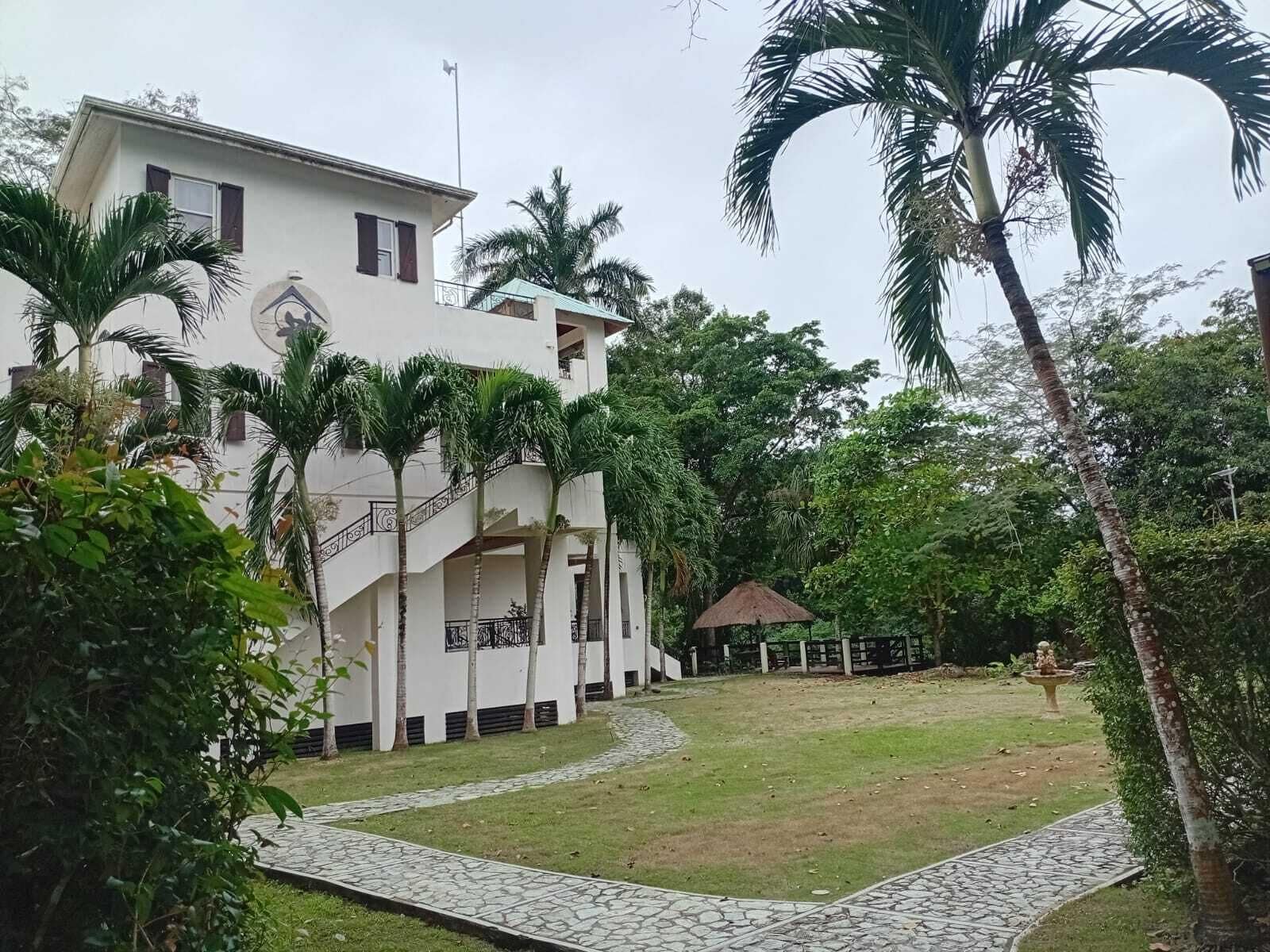 A white building with a staircase and a covered outdoor area.