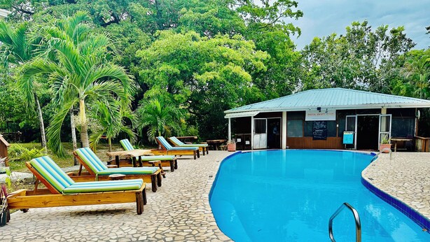 A pool area with lounge chairs and a covered seating area. - Black Orchid Resort (Burrell Boom)