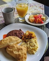 Un plato con alimentos, entre ellos un pastel, un plato amarillo y una salsa roja.