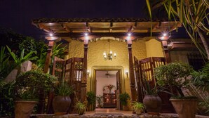 A traditional courtyard with a wooden pergola, potted plants, and a chandelier. - Los Robles Charming Colonial Boutique Hotel (Managua)