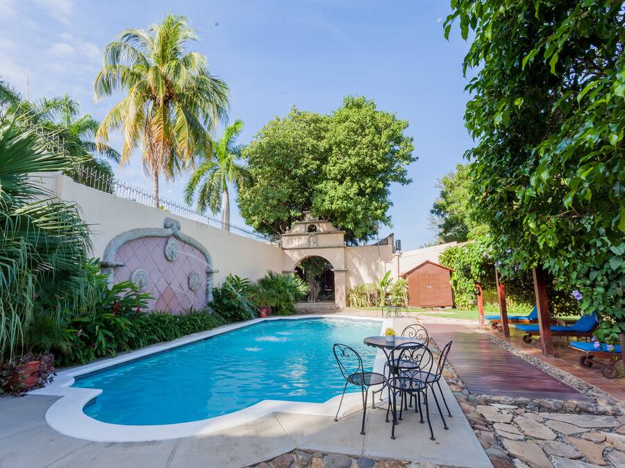 Una piscina al aire libre, sillones reclinables de piscina