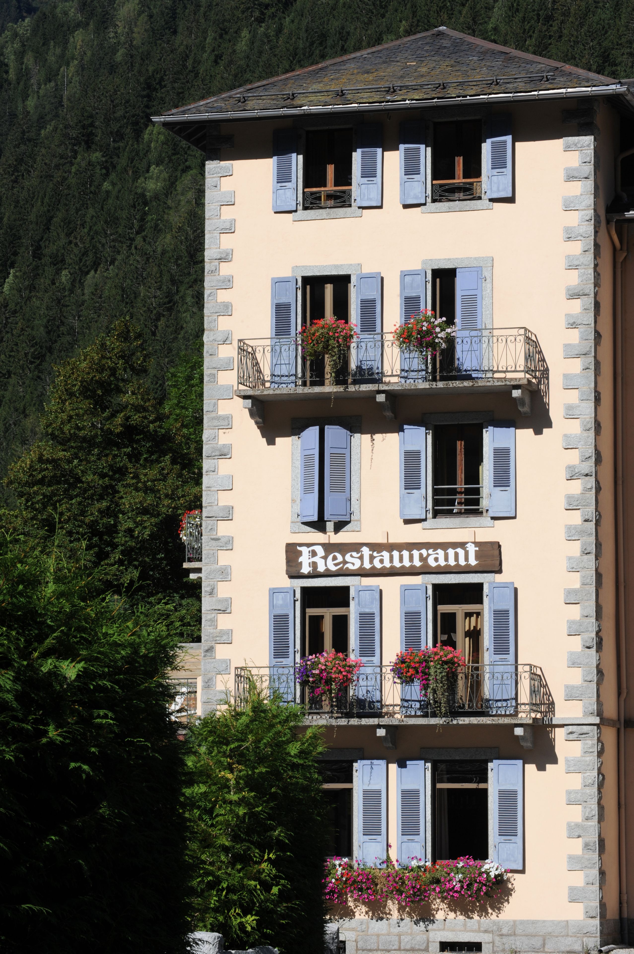 Un immeuble à plusieurs étages dont la façade porte une enseigne indiquant « Restaurant ».