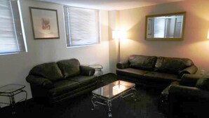 A living room with two couches, a coffee table, and a lamp. - San Francisco Business Class (Irapuato)