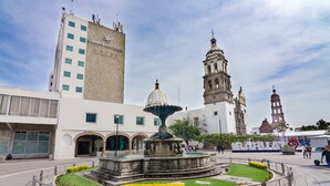 A historic plaza with a fountain, a bell tower, and a building labeled "San Francisco Hotel." - San Francisco Business Class (Irapuato)