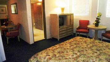 Een hotelkamer met een bed, een televisie, een bureau en een stoel.