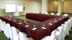 A conference room with a long table, white chairs, and a whiteboard. - San Francisco Business Class (Irapuato)