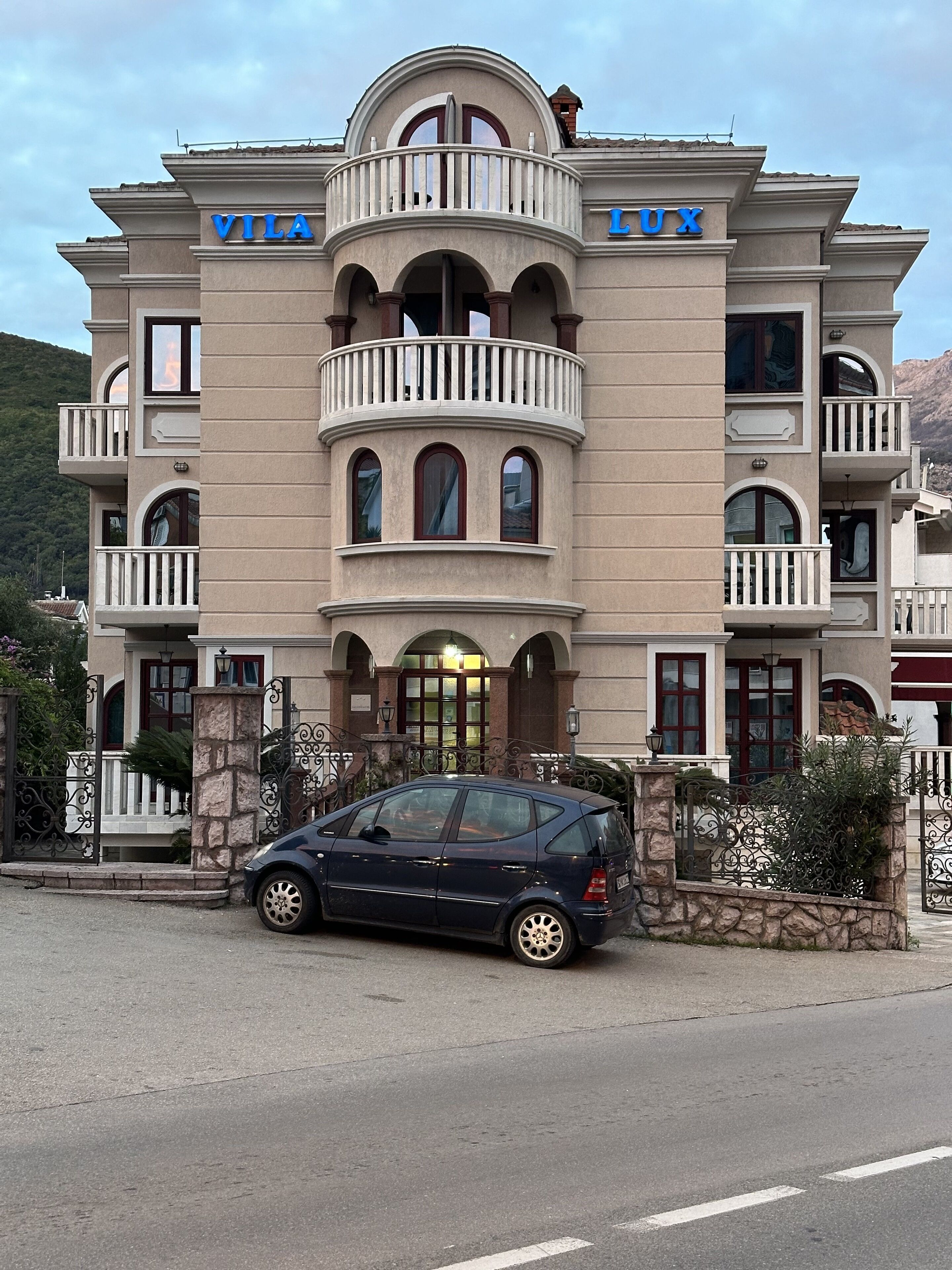 A large, multi-story building with balconies and arched windows, labeled "VILA LUX".