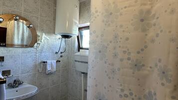 Baño con inodoro, lavamanos y cortina de ducha.