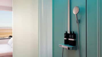 Une salle de bain moderne avec une douche, un lavabo intégré et un miroir.