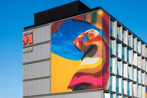 A hotel building with a large billboard featuring a colorful advertisement.