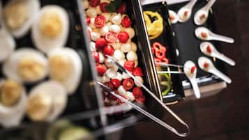Un buffet proposant une variété de plats, notamment des boules de mozzarella, des tomates cerises et des brochettes.