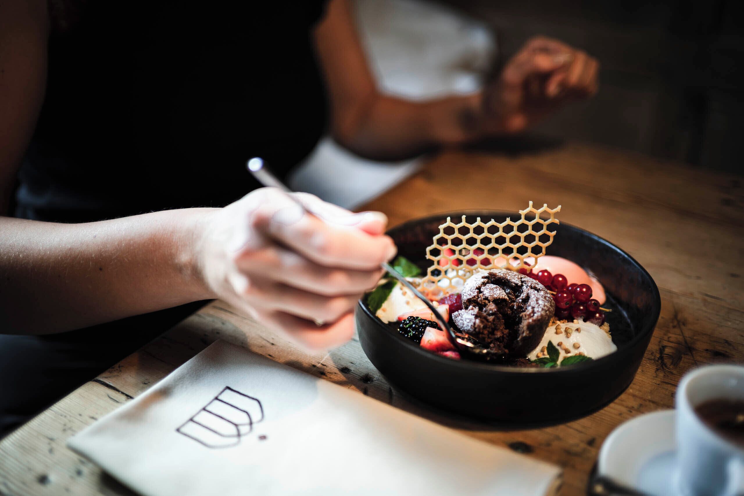 A person dining at a table with a bowl of food.