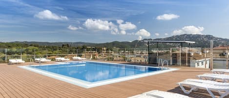 Una piscina al aire libre, tumbonas