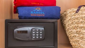 Un panel de teclado de seguridad, una toalla roja y azul con el logotipo de 'Marsol Hotels & Resorts', y un bolso tejido.