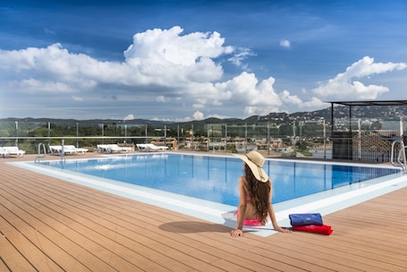 Una piscina al aire libre, sillones reclinables de piscina. Apartaments Condado