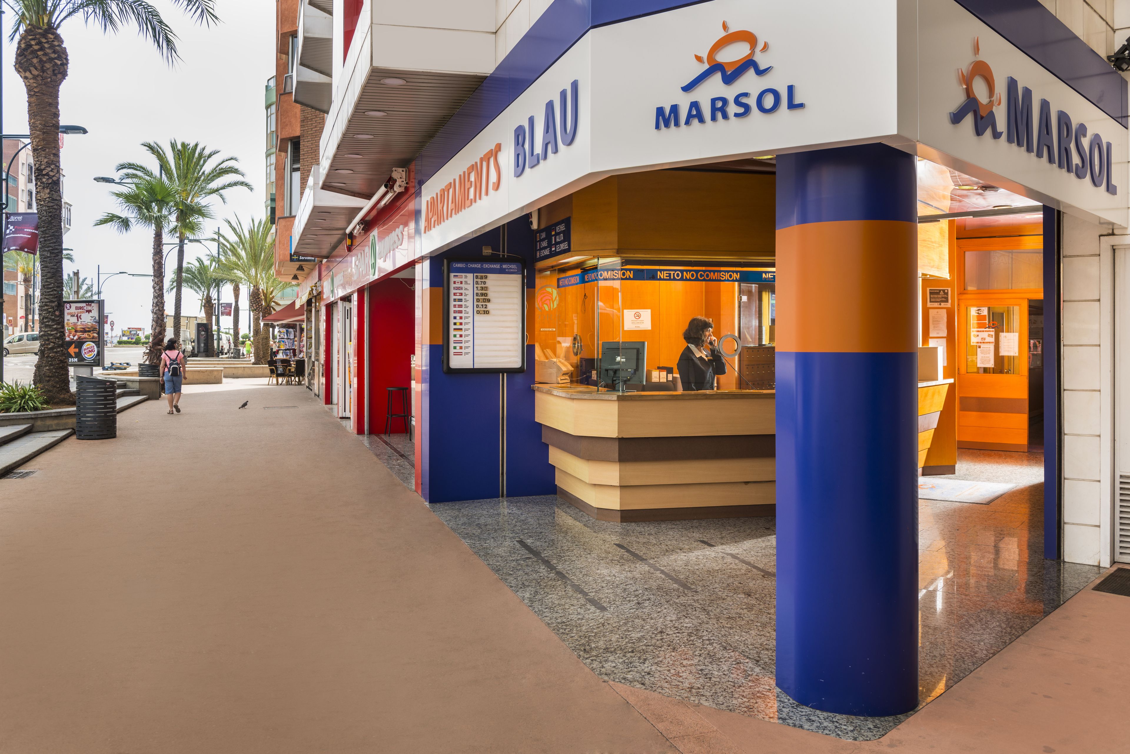 Un hôtel Marsol doté d’un comptoir d’accueil, d’un annuaire et d’une façade bleue et orange.