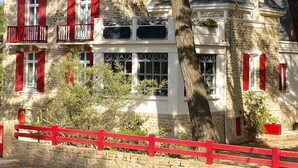 Un edificio de piedra con contraventanas rojas, un balcón y un letrero que dice "Supermart".