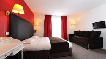 Una habitación de hotel con cama, escritorio, sofá y televisor.