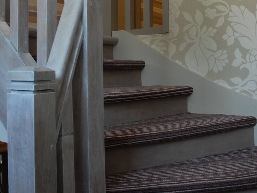Un escalier avec des marches en bois et des balustrades blanches.