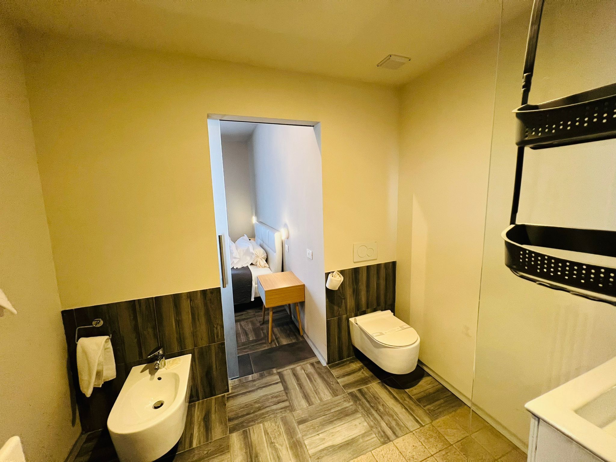 Een kleine hotelbadkamer met een wc, wastafel en bidet.