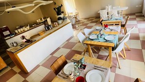 Un comedor con isla central, piso a cuadros y zona de cocina con pileta y mostrador.