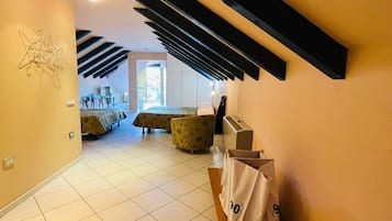 Habitación cuádruple Deluxe, vista al jardín | Escritorio y ropa de cama