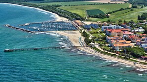 Un pueblo costero con puerto deportivo, playa y edificios residenciales.