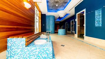 Experience the unique bathroom design with a large round sink, blue mosaic tile floor, and wooden paneling.