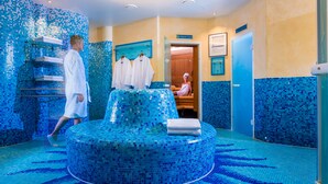 Un spa moderno con una piscina con mosaicos, una sauna y un vestuario.