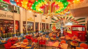 A vibrant restaurant interior with colorful decor, tables, and chairs arranged for dining. - Novotel Living Bangkok Sukhumvit Legacy (Bangkok)