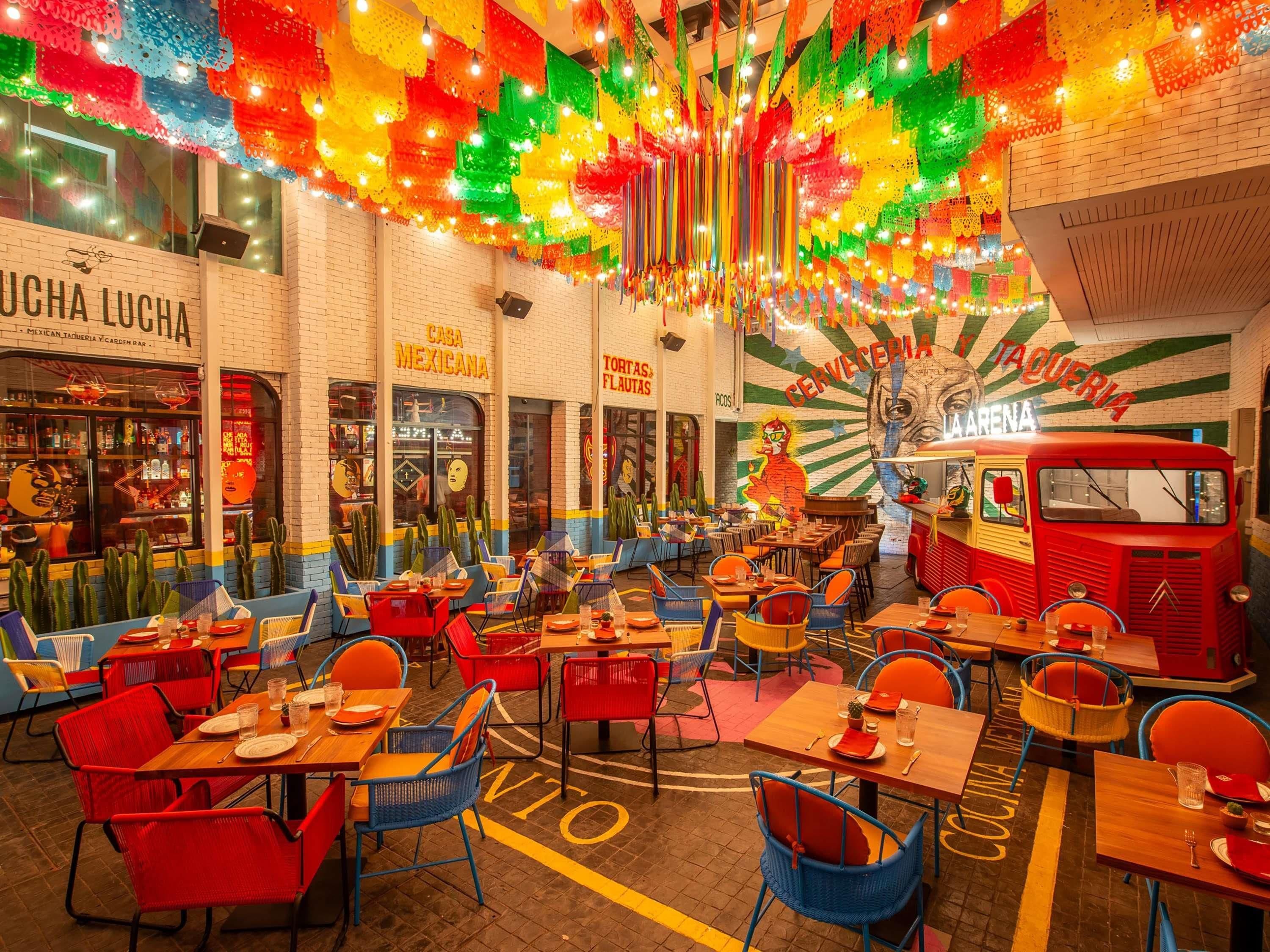 A vibrant restaurant interior with colorful decor, tables, and chairs arranged for dining.