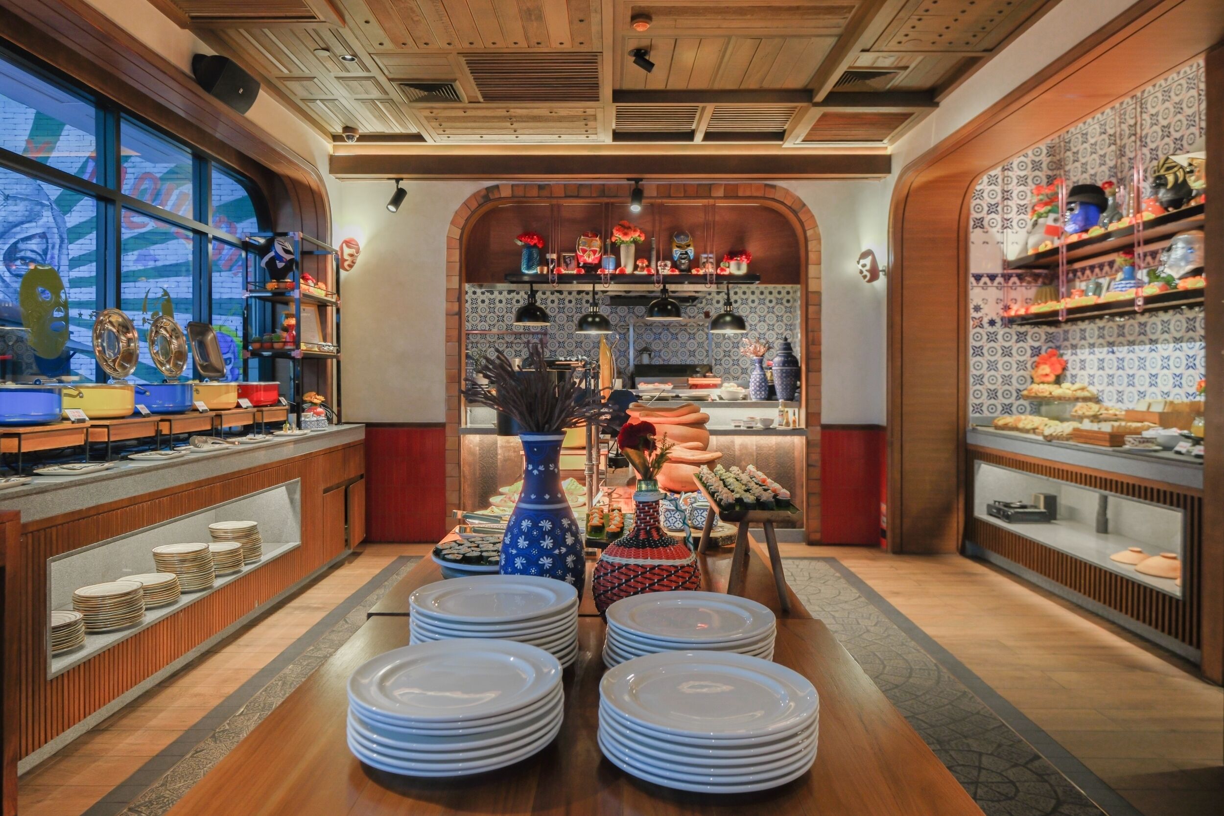 A buffet setup with plates, bowls, and various food items.