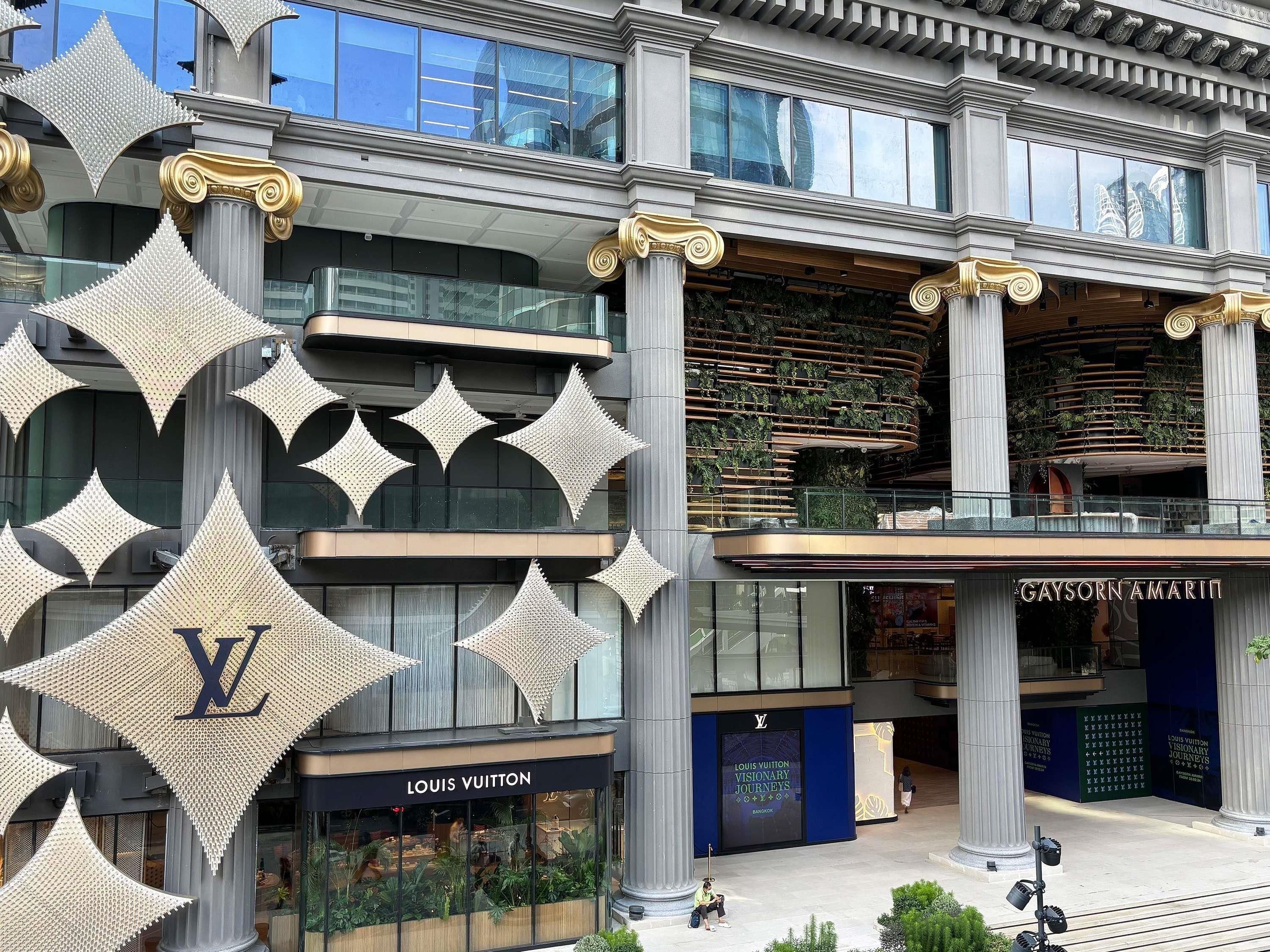A Louis Vuitton store with a prominent 'Louis Vuitton' sign and a 'Visionary Journeys' advertisement.