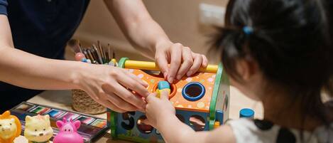 A person and a child interacting with a colorful toy.