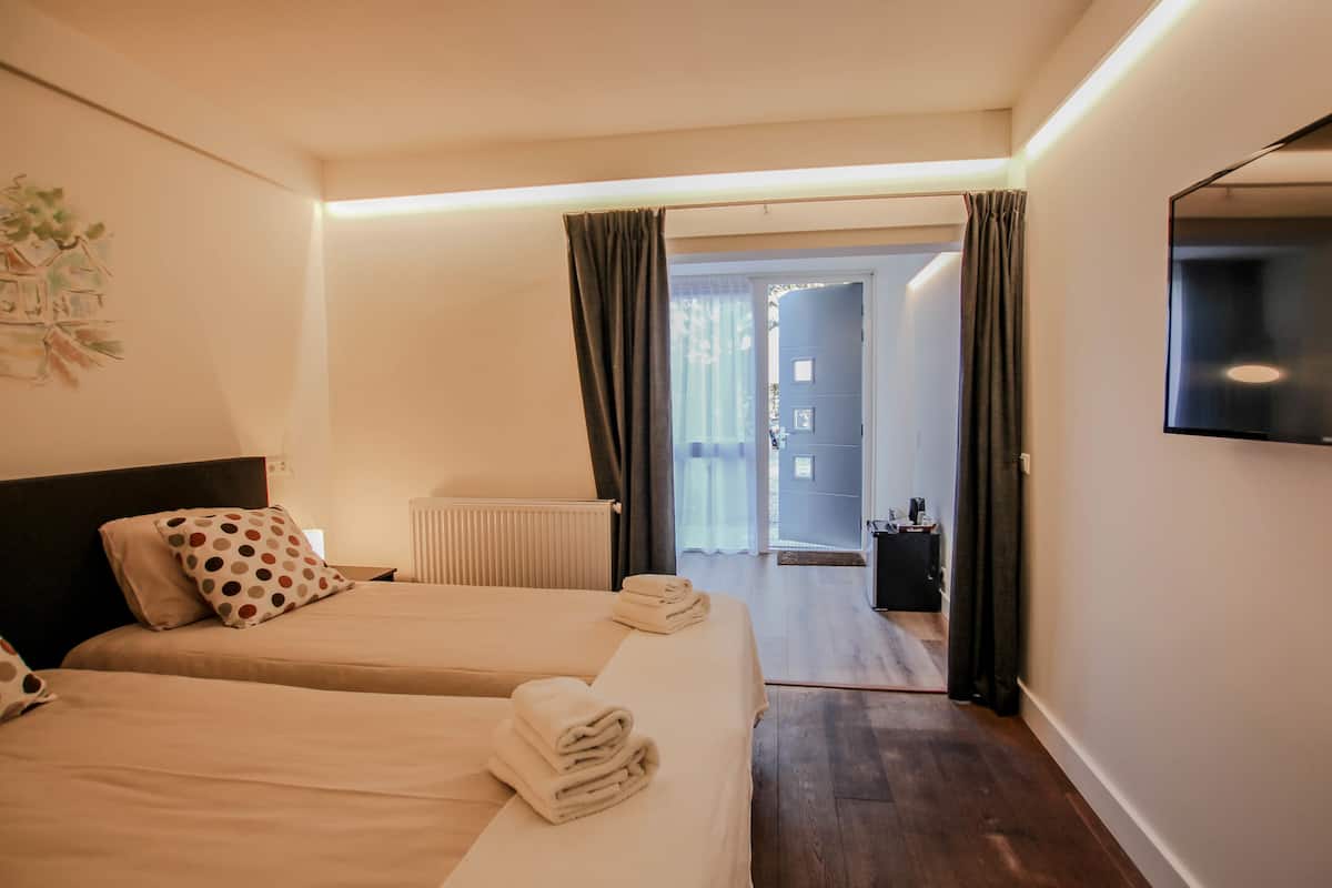Una habitación de hotel con dos camas, un televisor de pantalla plana y vistas al exterior.