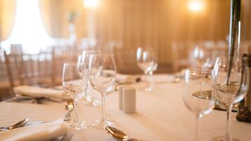 Mesa lista para comer con copas de vino, platos y cubiertos.