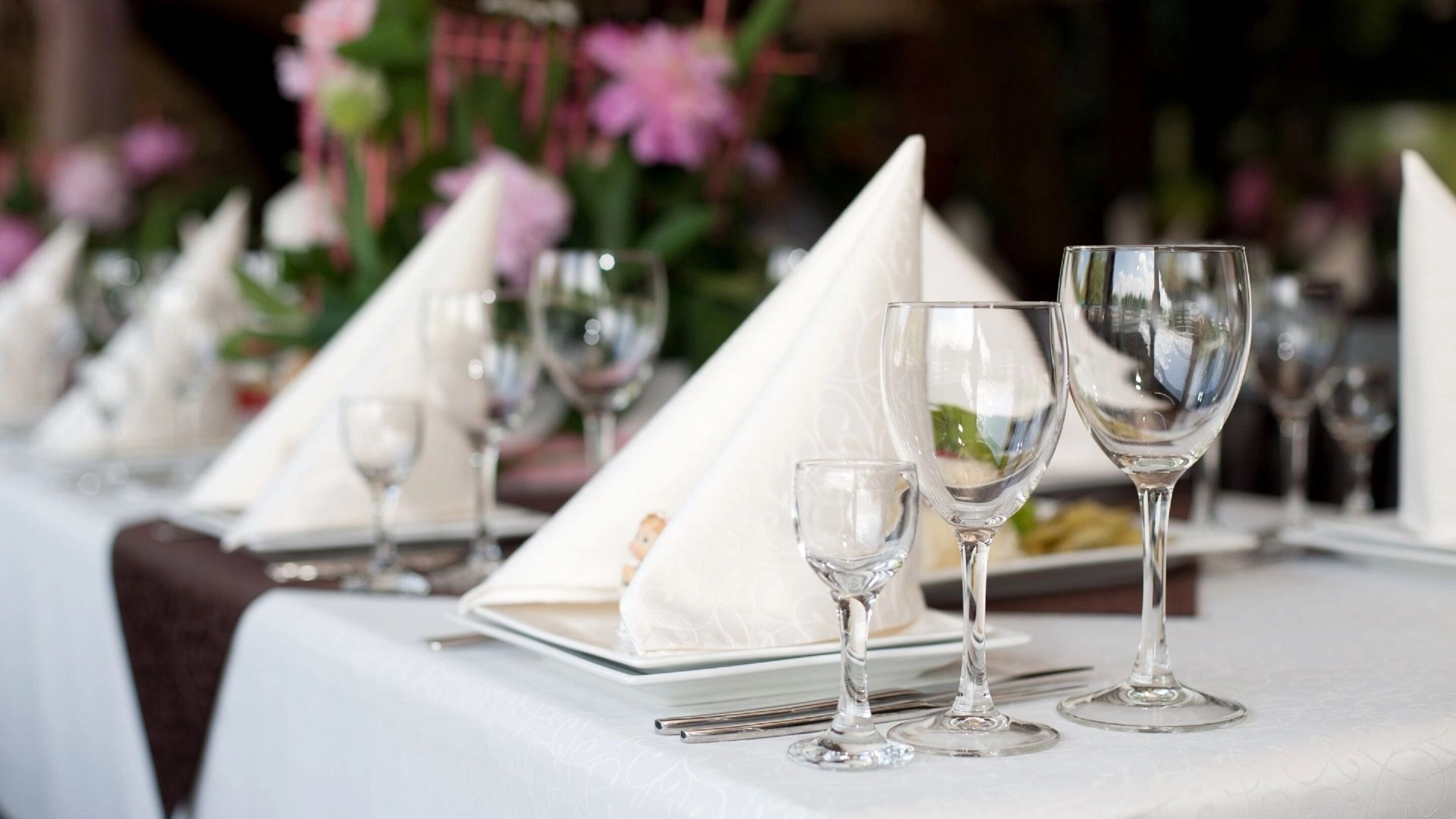 Ein gedeckter Tisch mit Weingläsern und Servietten, der eine festliche Atmosphäre zum Essen vermittelt.