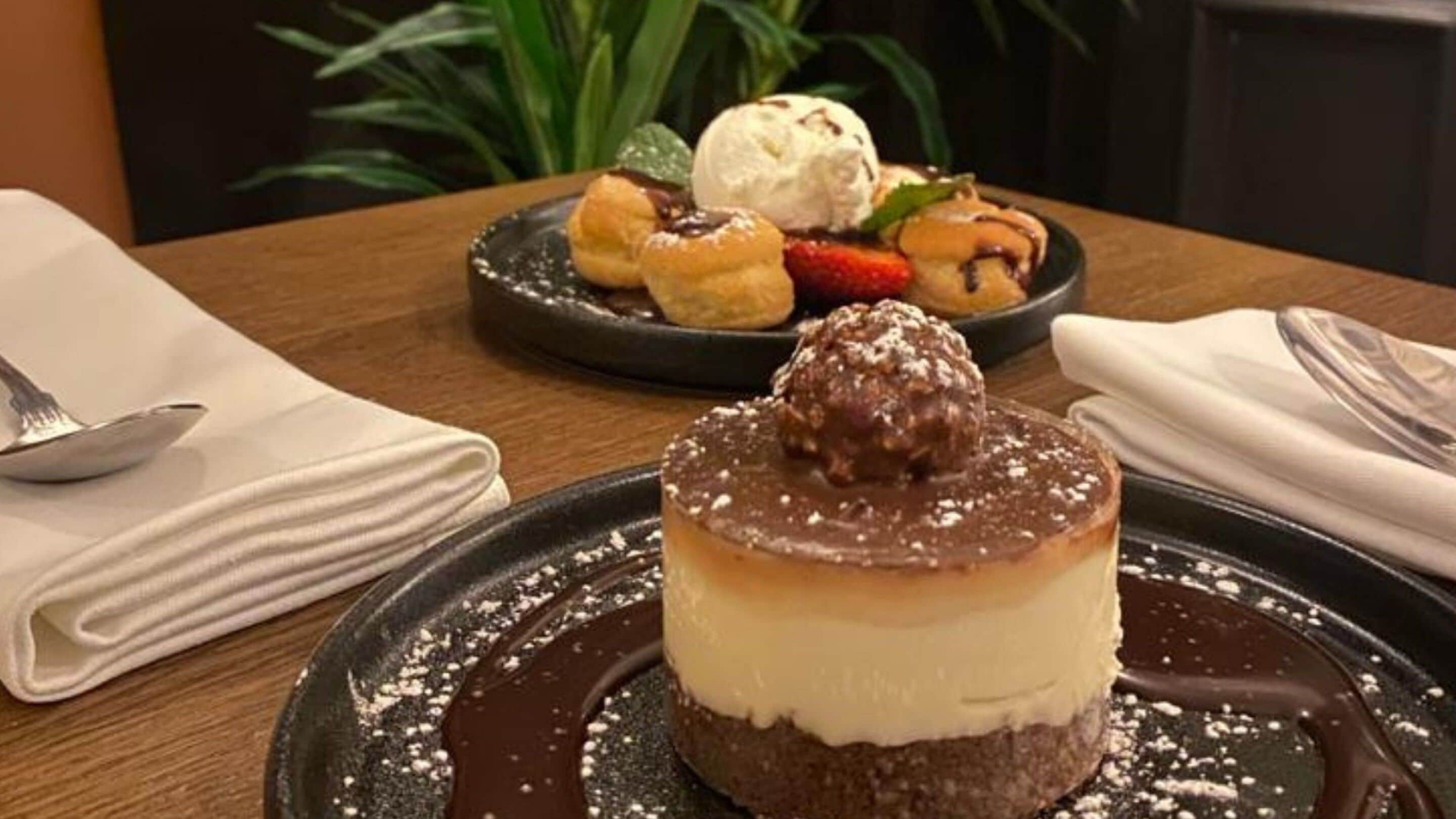 Un piattino con una torta al cioccolato, guarnita con una ciliegia e una pallina di gelato.