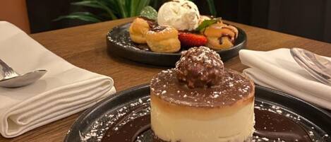 Un piattino con una torta al cioccolato, guarnita con una ciliegia e una pallina di gelato.