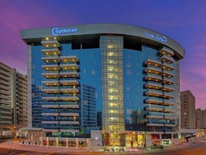A modern hotel with a curved facade, multiple balconies, and a prominent entrance. - Copthorne Hotel Dubai (Dubai)