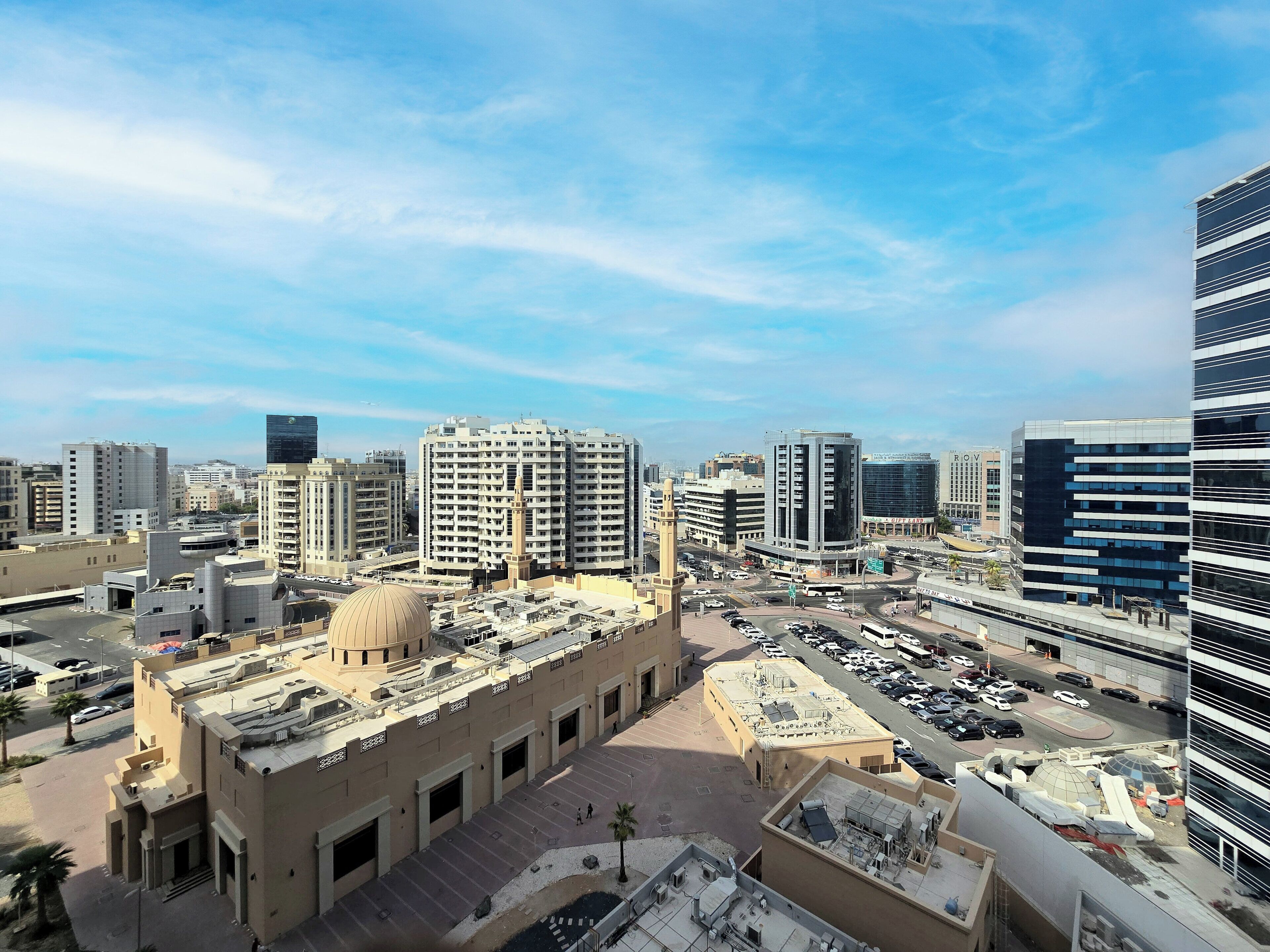 A cityscape with modern buildings, a large dome structure, and a busy intersection.