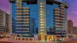A modern hotel with a curved facade, multiple balconies, and a prominent entrance. - Copthorne Hotel Dubai (Dubai)