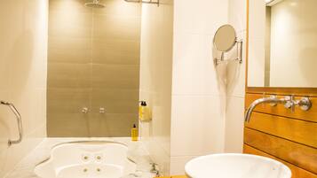 Une salle de bain avec une baignoire sur pieds, un lavabo et un meuble-lavabo en bois.